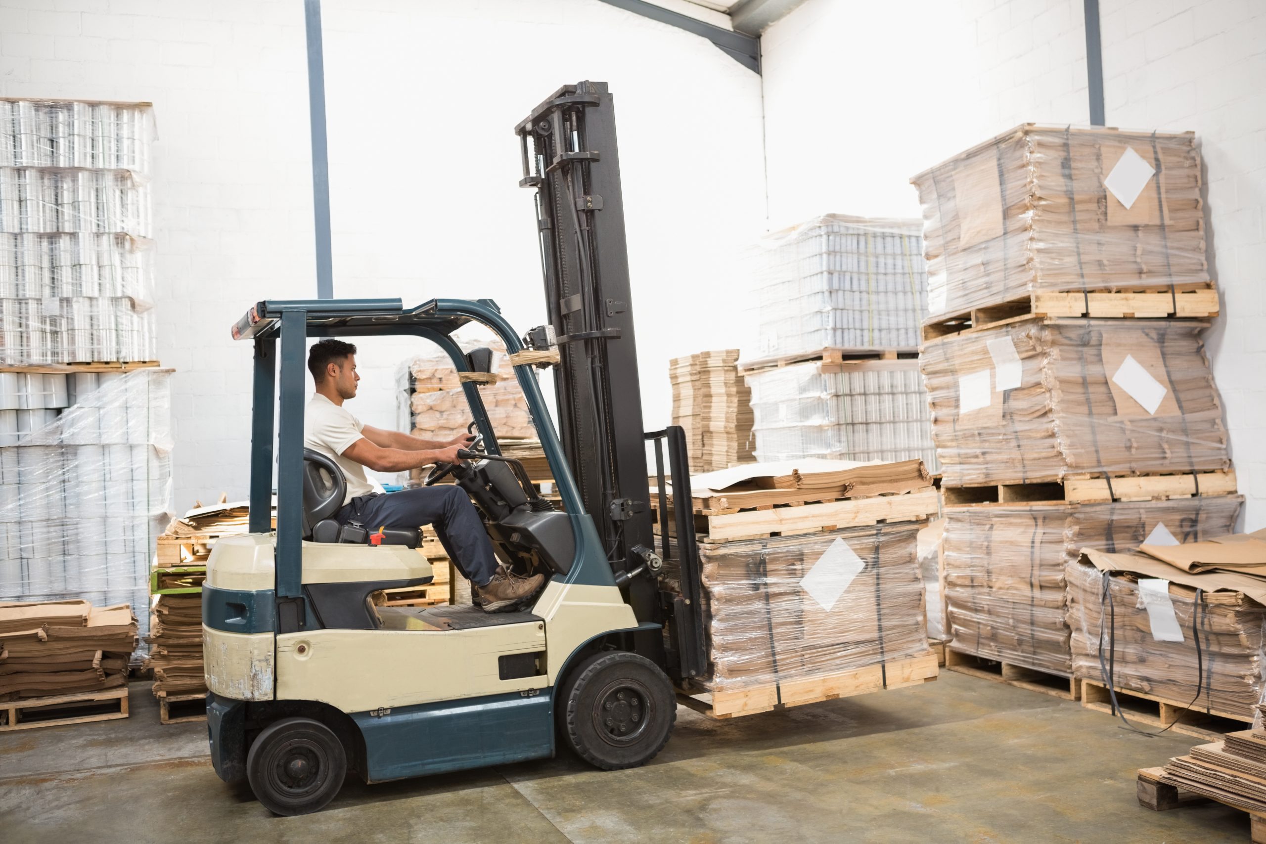 Driver operating forklift machine in a large warehouse