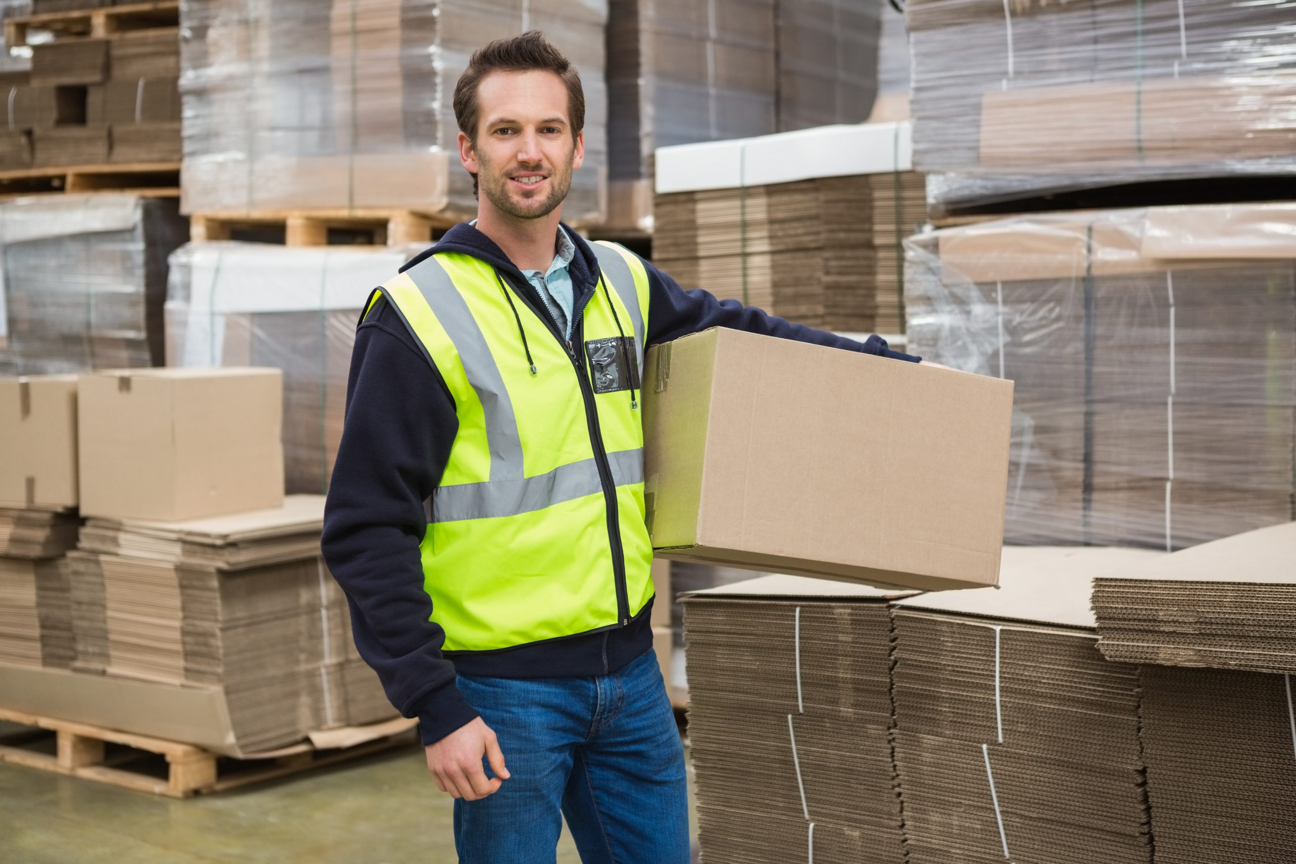 Portrait of worker carrying box in the warehouse